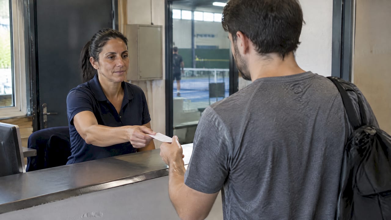 L'organizzatrice consegna un biglietto alla cassa del locale